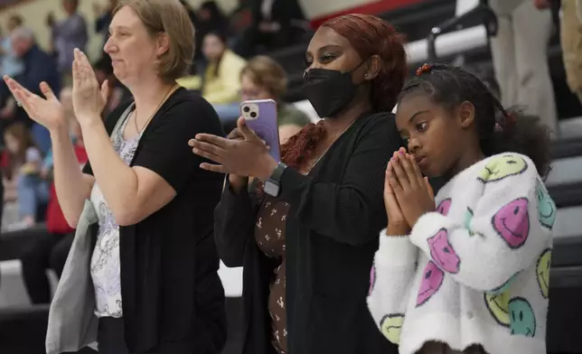 Mary Engidaw, center, and her daughter Harmony Hall, right, applaud during a Worthington High School choir concert in Worthington, Minn., on Monday, Oct. 21, 2024. (AP Photo/Jessie Wardarski)