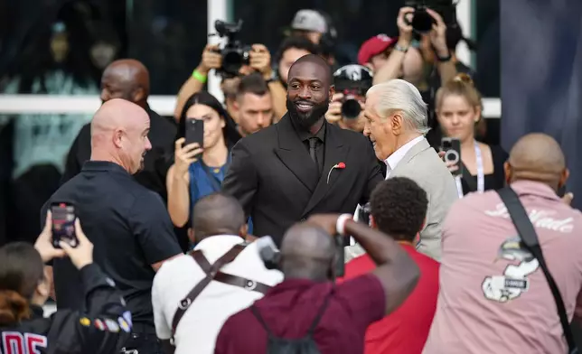 Former Miami Heat NBA basketball player Dwyane Wade, center, arrives at his statue unveiling ceremony outside Kaseya Center, Sunday, Oct. 27, 2024, in Miami, Fla. (AP Photo/Michael Laughlin)