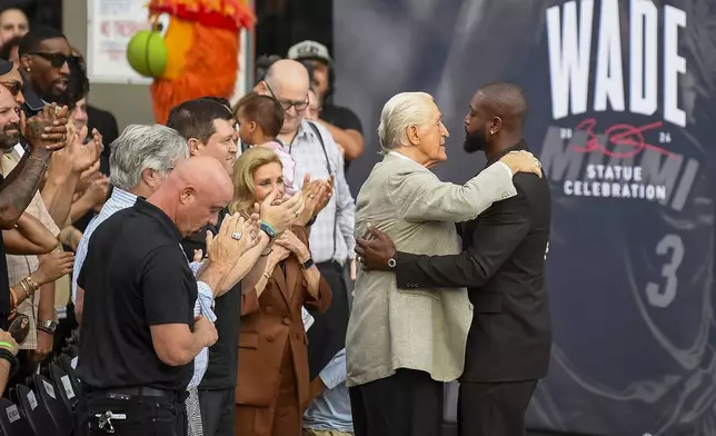 Former Miami Heat NBA basketball player Dwyane Wade, right, hugs Heat president Pat Reiley during a statue unveiling ceremony outside the Kaseya Center, Sunday, Oct. 27, 2024, in Miami, Fla. (AP Photo/Michael Laughlin)