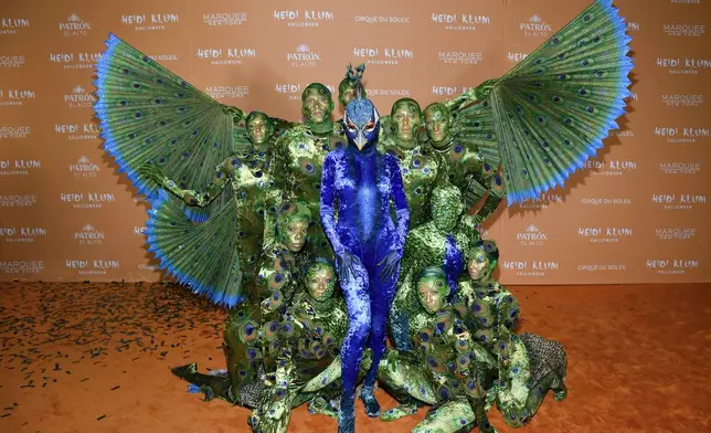 FILE - Heidi Klum, center, in blue, arrives at her 22nd annual Halloween party at Marquee on Tuesday, Oct. 31, 2023, in New York. (Photo by Evan Agostini/Invision/AP)