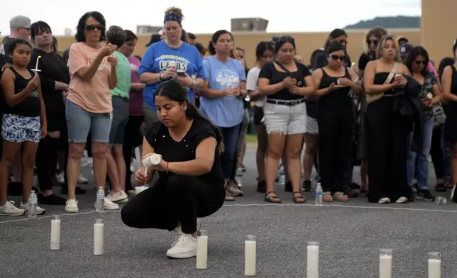 Tennessee Immigrant and Refugee Rights Coalition worker Ana Gutierrez, lights a candle during a vigil for victims of the Impact Plastics tragedy in the days after Hurricane Helene in Erwin, Tenn., on Thursday, Oct. 3, 2024. (AP Photo/Jeff Roberson)