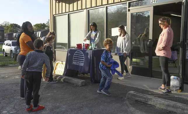 Madiera Maxwell, left, checks in her two children, nephew and niece to the Project:Camp pop-up daycamp for families impacted by Hurricane Helene in Brevard, N.C., Tuesday, Oct. 8, 2024. (AP Photo/Gabriela Aoun Angueira)