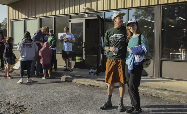 Max and Aviva Weissman stand outside the Boys and Girls Club of Transylvania County in Brevard, N.C., Tuesday, Oct. 8, 2024 after dropping off their kids at Project Camp. (AP Photo/Gabriela Aoun Angueira)