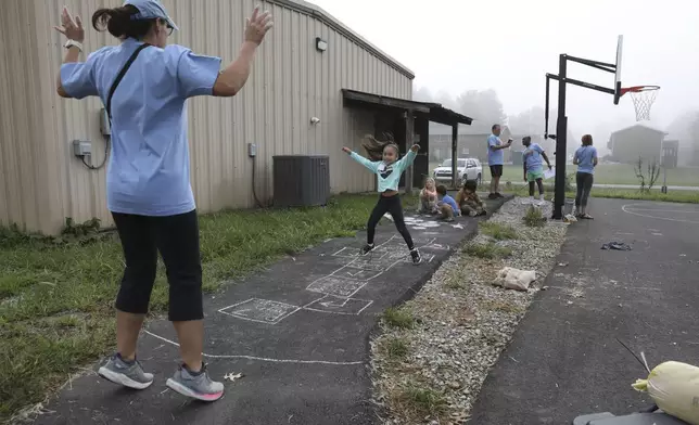 A girl plays hopscotch at the Project:Camp pop-up daycamp for families impacted by Hurricane Helene in Brevard, N.C., Monday, Oct. 7, 2024. (AP Photo/Gabriela Aoun Angueira)