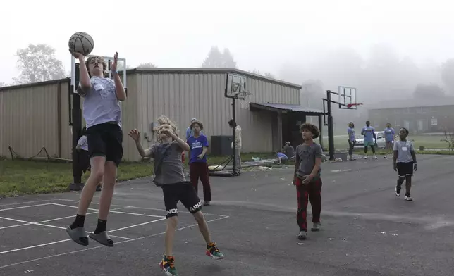 Boys play basketball at the Project:Camp pop-up daycamp for families impacted by Hurricane Helene in Brevard, N.C., Monday, Oct. 7, 2024. (AP Photo/Gabriela Aoun Angueira)