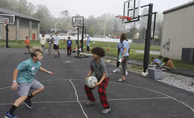 Boys play basketball at the Project:Camp pop-up daycamp for families impacted by Hurricane Helene in Brevard, N.C., Monday, Oct. 7, 2024. (AP Photo/Gabriela Aoun Angueira)