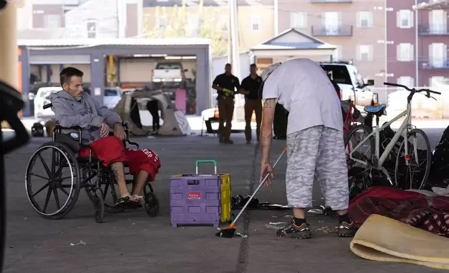 A man living in a homeless encampment sweeps up after Louisiana State police gave instructions for them to move to a different pre-designated location as they perform a sweep in advance of a Taylor Swift concert in New Orleans, Wednesday, Oct. 23, 2024. (AP Photo/Gerald Herbert)