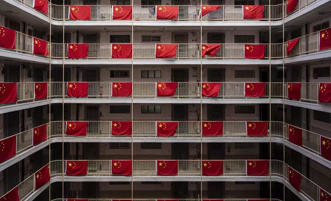 Flags of China are hung in a residential building to mark the 75th National Day of the People's Republic of China in Hong Kong, Tuesday, Oct. 1, 2024. (AP Photo/Chan Long Hei)