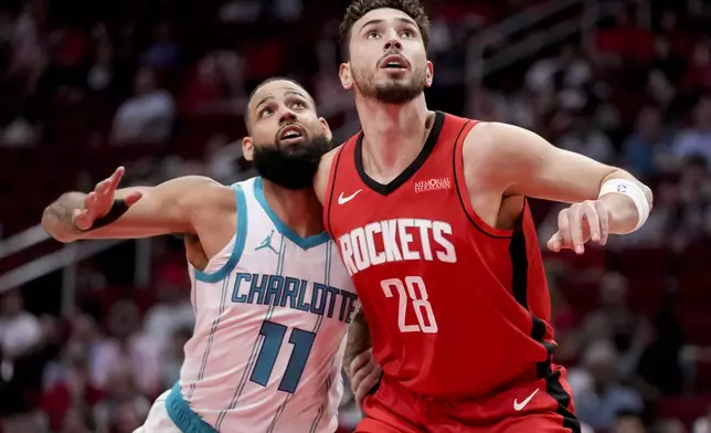 Houston Rockets center Alperen Sengun (28) and Charlotte Hornets forward Cody Martin watch a free throw during the first half of an NBA basketball game Wednesday, Oct. 23, 2024, in Houston. (AP Photo/Eric Christian Smith)