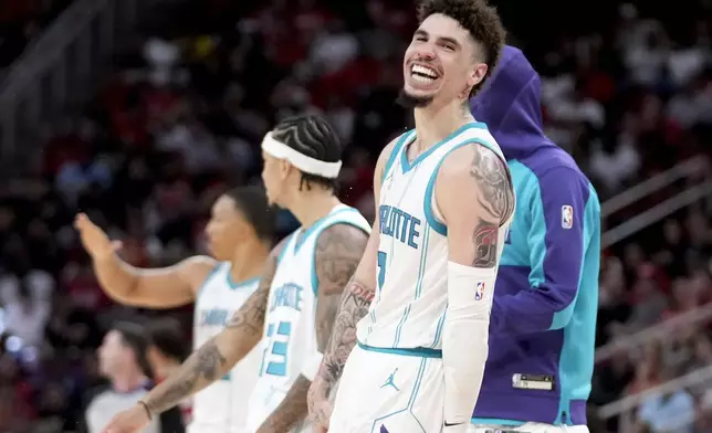 Charlotte Hornets guard LaMelo Ball, right, reacts after making a three point basket against the Houston Rockets during the second half of an NBA basketball game Wednesday, Oct. 23, 2024, in Houston. (AP Photo/Eric Christian Smith)