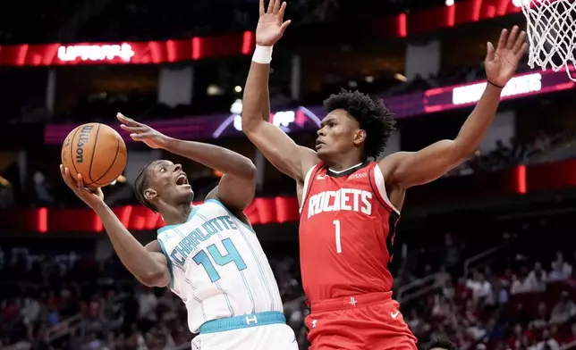 Charlotte Hornets forward Moussa Diabate (14) shoots as Houston Rockets forward Amen Thompson defends during the first half of an NBA basketball game Wednesday, Oct. 23, 2024, in Houston. (AP Photo/Eric Christian Smith)