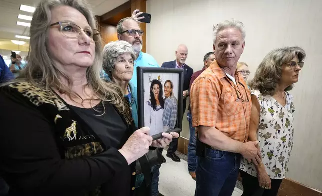 Elizabeth Ferrari, sister of Dennis Tuttle, holds a photo of her brother and Rhogena Nicholas, outside the courtroom after former Houston police officer Gerald Goines was sentenced to 60 years behind bars on a pair of felony murder convictions on Tuesday, Oct. 8, 2024, in Houston. Goines was found guilty of felony murder in the 2019 deaths of Tuttle and Nicholas. (Brett Coomer/Houston Chronicle via AP)