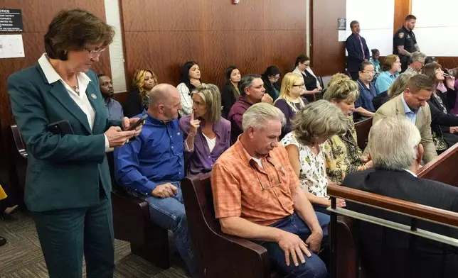 Harris County District Attorney Kim Ogg, left, stand with the families Dennis Tuttle and Rhogena Nicholas after former Houston police officer Gerald Goines was sentenced to 60 years behind bars on a pair of felony murder convictions on Tuesday, Oct. 8, 2024, in Houston. Goines was found guilty of felony murder in the 2019 deaths of Tuttle and Nicholas. (Brett Coomer/Houston Chronicle via AP)