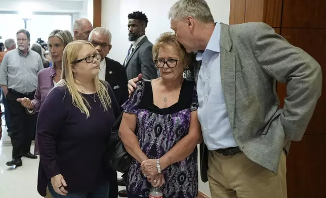 The family of Dennis Tuttle and Rhogena Nicholas gather outside the courtroom after former Houston police officer Gerald Goines was sentenced to 60 years behind bars on a pair of felony murder convictions on Tuesday, Oct. 8, 2024, in Houston. Goines was found guilty of felony murder in the 2019 deaths of Tuttle and Nicholas. (Brett Coomer/Houston Chronicle via AP)