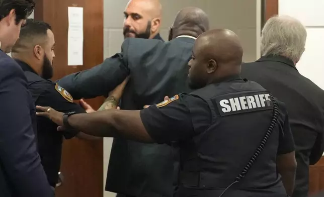 Former Houston police officer Gerald Goines, center, is rushed out of the courtroom after having a medical emergency during the punishment phase of his felony murder trial Thursday, Oct. 3, 2024, at the Harris County Criminal courthouse in Houston. (Melissa Phillip/Houston Chronicle via AP)/Houston Chronicle via AP)