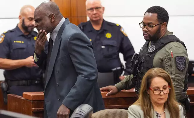 Former Houston police officer Gerald Goines is led through the courtroom by deputies after he was sentenced to 60 years behind bars on a pair of felony murder convictions on Tuesday, Oct. 8, 2024, in Houston. Goines was found guilty of felony murder in the 2019 deaths of Dennis Tuttle and Rhogena Nicholas. (Brett Coomer/Houston Chronicle via AP)