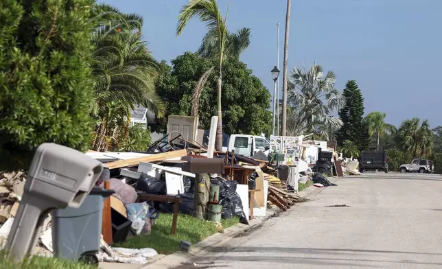 Debris from homes flooded in Hurricane Helene sits curbside as Hurricane Milton approaches on Tuesday, Oct. 8, 2024, in Port Richey, Fla. (AP Photo/Mike Carlson)