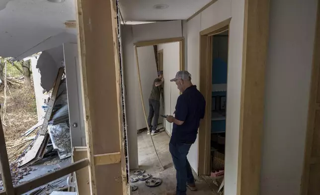 FEMA employee Jirau Alvaro works with Daniel Mancini, doing a report on the damage to his property on Sunday, Oct. 6, 2024 in rural Buncombe County, near Black Mountain, N.C. (Robert Willett/The News &amp; Observer via AP)