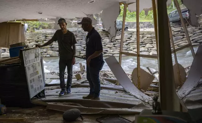 FEMA employee Jirau Alvaro works with Daniel Mancini, doing a report on the damage to his property on Sunday, Oct. 6, 2024 in rural Buncombe County, near Black Mountain, N.C. (Robert Willett/The News &amp; Observer via AP)