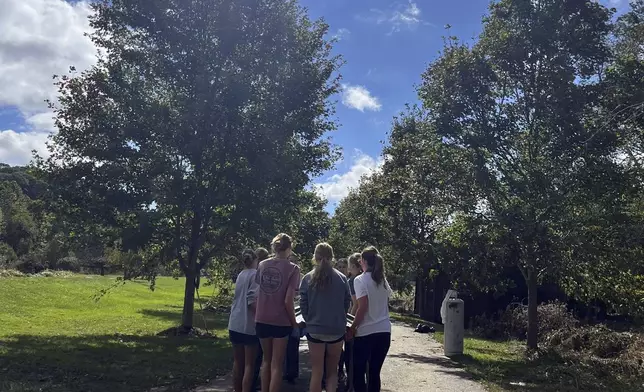 In this photo provided by Mary Walker, members of the girls cross country team at Watauga High School perform cleanup duties Wednesday, Oct. 2, 2024, along the Greenway Trail in Boone, N.C.. The area was hit hard by Hurricane Helene. (Mary Walker via AP)