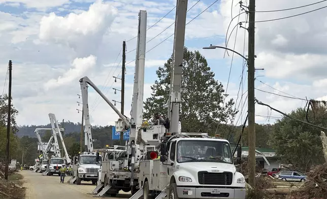 Contractors for Duke Energy rebuild destroyed electrical lines near the Swannanoa River in Asheville, N.C., Friday, Oct. 4, 2024. (AP Photo/Jeff Amy)