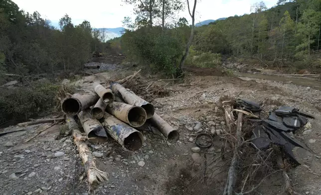 The remnants of a waterline serving Asheville, N.C., is piled up downstream from North Fork Reservoir, a main source of water for the city, Wednesday, Oct. 2, 2024, after the line was destroyed during Hurricane Helene in Black Mountain, N.C. (AP Photo/Jeff Roberson)