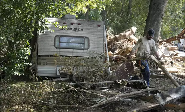 A person clears debris left in the aftermath of Hurricane Helene Saturday, Oct. 5, 2024, in Del Rio, Tenn. (AP Photo/Jeff Roberson)