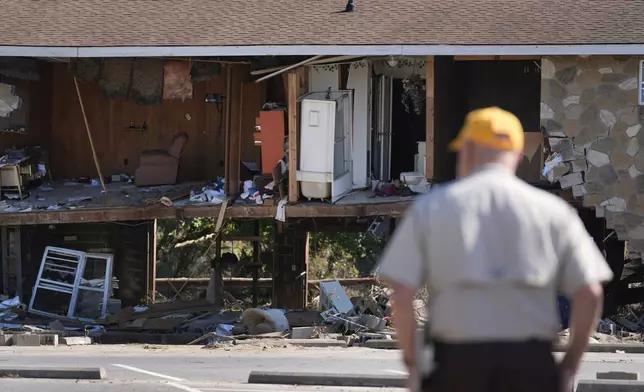 Paul Shaver looks a a building destroyed in the aftermath of Hurricane Helene Saturday, Oct. 5, 2024, in Newport, Tenn. (AP Photo/Jeff Roberson)