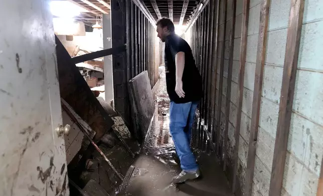 Contractor Joshua Taylor stands in the basement of a funeral home that was flooded in the aftermath of Hurricane Helene while working to clean up the building Saturday, Oct. 5, 2024, in Newport, Tenn. (AP Photo/Jeff Roberson)