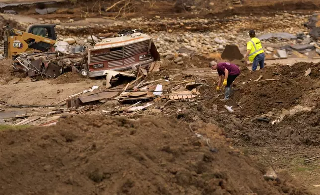 People clean up debris left in the aftermath of Hurricane Helene Friday, Oct. 4, 2024, in Erwin, Tenn. (AP Photo/Jeff Roberson)