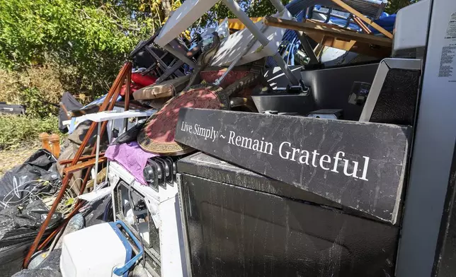 Contents of a home are piled on the side of a home after flooding from Hurricane Helene on Wednesday, Oct. 2, 2024, in Indian Rocks Beach, Fla. (AP Photo/Mike Carlson)