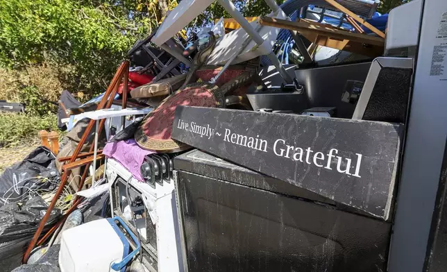 Contents of a home are plied on the side of a home after flooding from Hurricane Helene on Wednesday, Oct. 2, 2024, in Indian Rocks Beach, Fla. (AP Photo/Mike Carlson)