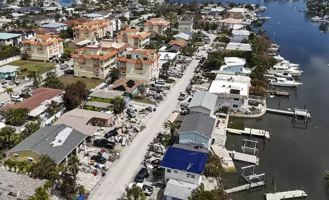 Contents of homes line the streets after flooding from Hurricane Helene on Wednesday, Oct. 2, 2024, in Reddington Shores, Fla. (AP Photo/Mike Carlson)