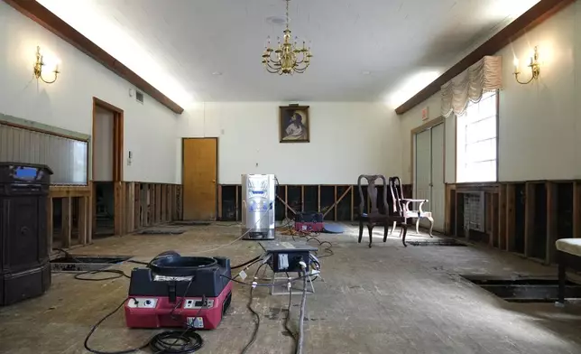 Air movers circulate the air in an effort to dry out the chapel inside Costner-Maloy Funeral Home Saturday, Oct. 5, 2024, which was flooded in the aftermath of Hurricane Helene, in Newport, Tenn. (AP Photo/Jeff Roberson)