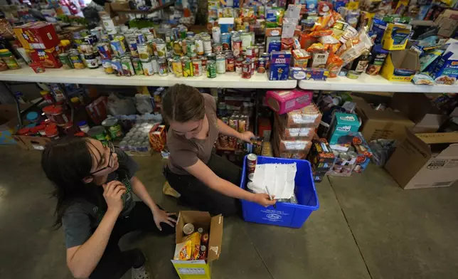 Volunteers gather food for families at the volunteer fire station in the aftermath of Hurricane Helene, Thursday, Oct. 3, 2024, in Pensacola, N.C. (AP Photo/Mike Stewart)