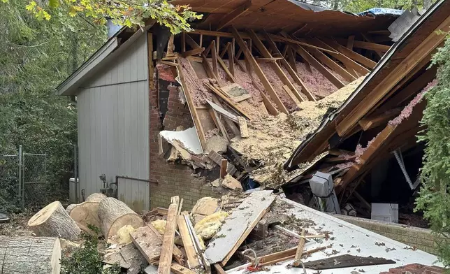 A damaged garage, caved in after a tree fell on it during the remnants of Hurricane Helene, is shown Friday, Oct. 4, 2024, in the Oak Forest neighborhood of Asheville, N.C. (AP Photo/Jeff Amy)