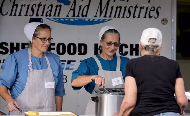 Loaves &amp; Fishes food group serve meals for residents in the aftermath of Hurricane Helene, Wednesday, Oct. 2, 2024, in Lake Lure, N.C. (AP Photo/Mike Stewart)