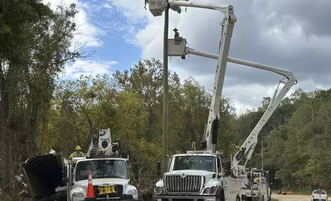 Contractors for Duke Energy rebuild destroyed electrical lines near the Swannanoa River in Asheville, N.C., Friday, Oct. 4, 2024. (AP Photo/Jeff Amy)