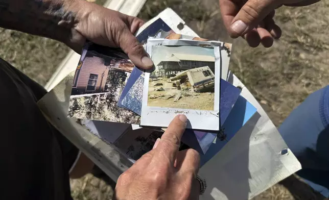 Leslie and J.D. High hold photos they found in the debris that Hurricane Helene left near their home in Dekle Beach in rural Taylor County, Fla., Friday, Sept. 27, 2024. Among the photos was a polaroid showing damage from a storm known as the "Storm of the Century" that hit the area in March, 1993. (AP Photo/Kate Payne)