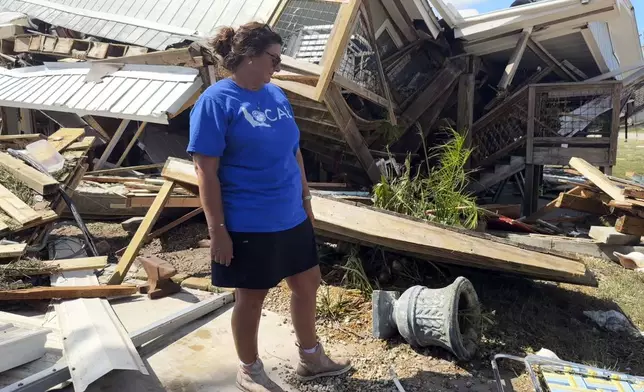 Laurie Lilliott stands amid the wreckage of her destroyed home in Dekle Beach in rural Taylor County, Fla., Friday, Sept. 27, 2024, in the aftermath of Hurricane Helene. (AP Photo/Kate Payne)