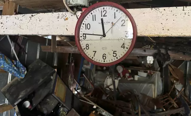 A waterlogged clock hangs a shed, Sunday, Sept 29, 2024, in Steinhatchee, Fla., in the aftermath of Hurricane Helene. (AP Photo/Kate Payne)