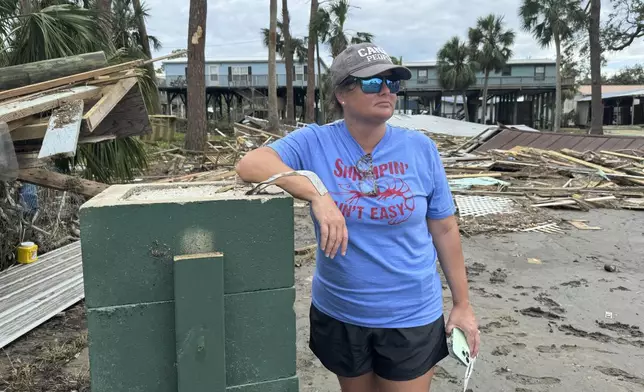 Brooke Hiers stands in front of where her home used to sit in Horseshoe Beach, Fla., Monday, Sept. 30, 2024, in the aftermath of Hurricane Helene. She and her husband had just rebuilt the home after Hurricane Idalia hit in August, 2023, before Hurricane Helene blew the house off its pilings and floated it into the neighbor's yard next door. (AP Photo/Kate Payne)