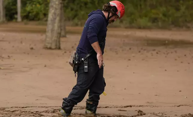 FILE - A fireman walks through mud as they search for victims of flooding in the aftermath of Hurricane Helene, Oct. 1, 2024, in Swannanoa, N.C. (AP Photo/Mike Stewart, File)