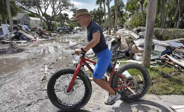 FILE - Arnie Bellini surveys the damages caused from Hurricane Helene on a street in Clearwater Beach, Fla., Oct. 8, 2024. (AP Photo/Chris O'Meara, File)