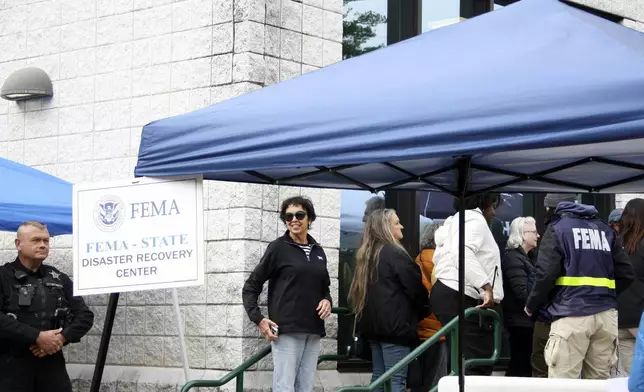 People gather at a FEMA Disaster Recovery Center at A.C. Reynolds High School in Asheville, N.C.,, Tuesday, Oct. 15, 2024. (AP Photo/Makiya Seminera)