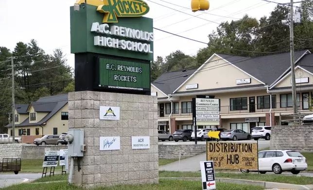 Signs are seen at a FEMA Disaster Recovery Center at A.C. Reynolds High School in Asheville, N.C., Tuesday, Oct. 15, 2024. (AP Photo/Makiya Seminera)