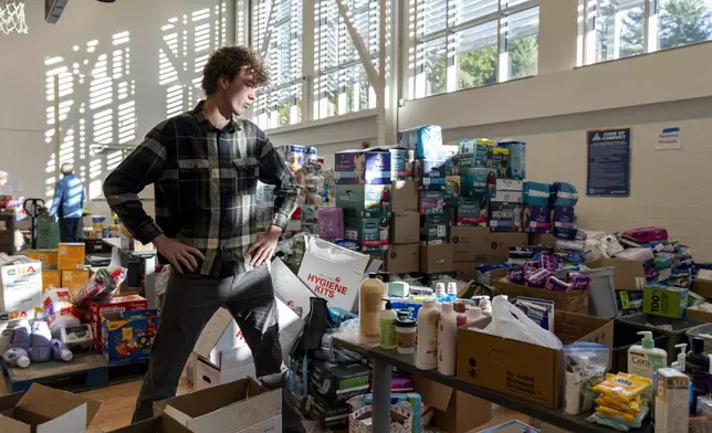 High school senior Nathan Flaherty pauses while packing hygiene kits for people in need of supplies as he volunteers in the aftermath of Hurricane Helene, Wednesday, Oct. 16, 2024, at the Dr. Wesley Grant Sr. Southside Community Center in Asheville, N.C. (AP Photo/Stephanie Scarbrough)