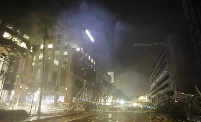 A crane is seen across 1st Avenue South near the Tampa Bay Times offices in St. Petersburg, Florida, Thursday, Oct. 10, 2024, as Hurricane Milton's strong winds tore through the area. (Chris Urso/Tampa Bay Times via AP)