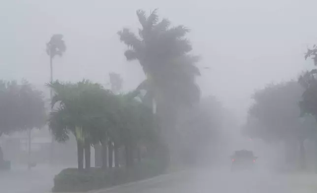 A Lee County Sheriff's officer patrols the streets of Cape Coral, Fla., as heavy rain falls ahead of Hurricane Milton, Wednesday, Oct. 9, 2024. (AP Photo/Marta Lavandier)