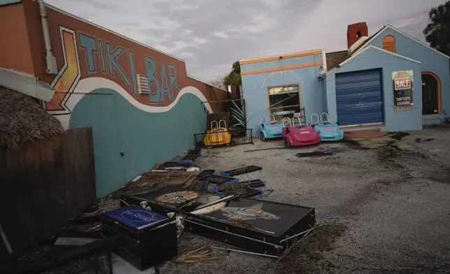 A broken sign and other debris lie alongside Gilligan's Island Bar &amp; Grill after the passage of Hurricane Milton, in Siesta Key, Fla., Thursday, Oct. 10, 2024. (AP Photo/Rebecca Blackwell)